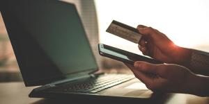 Person with laptop and credit card paying bills online