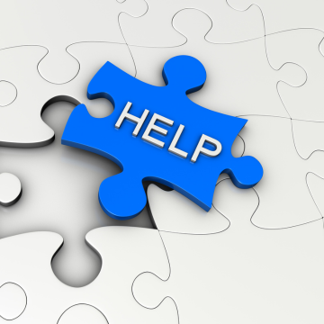 Blue puzzle piece with the word "HELP" fitting into a larger puzzle.
