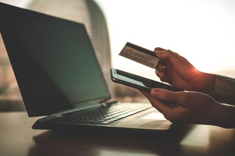 Person with laptop and credit card paying bills online